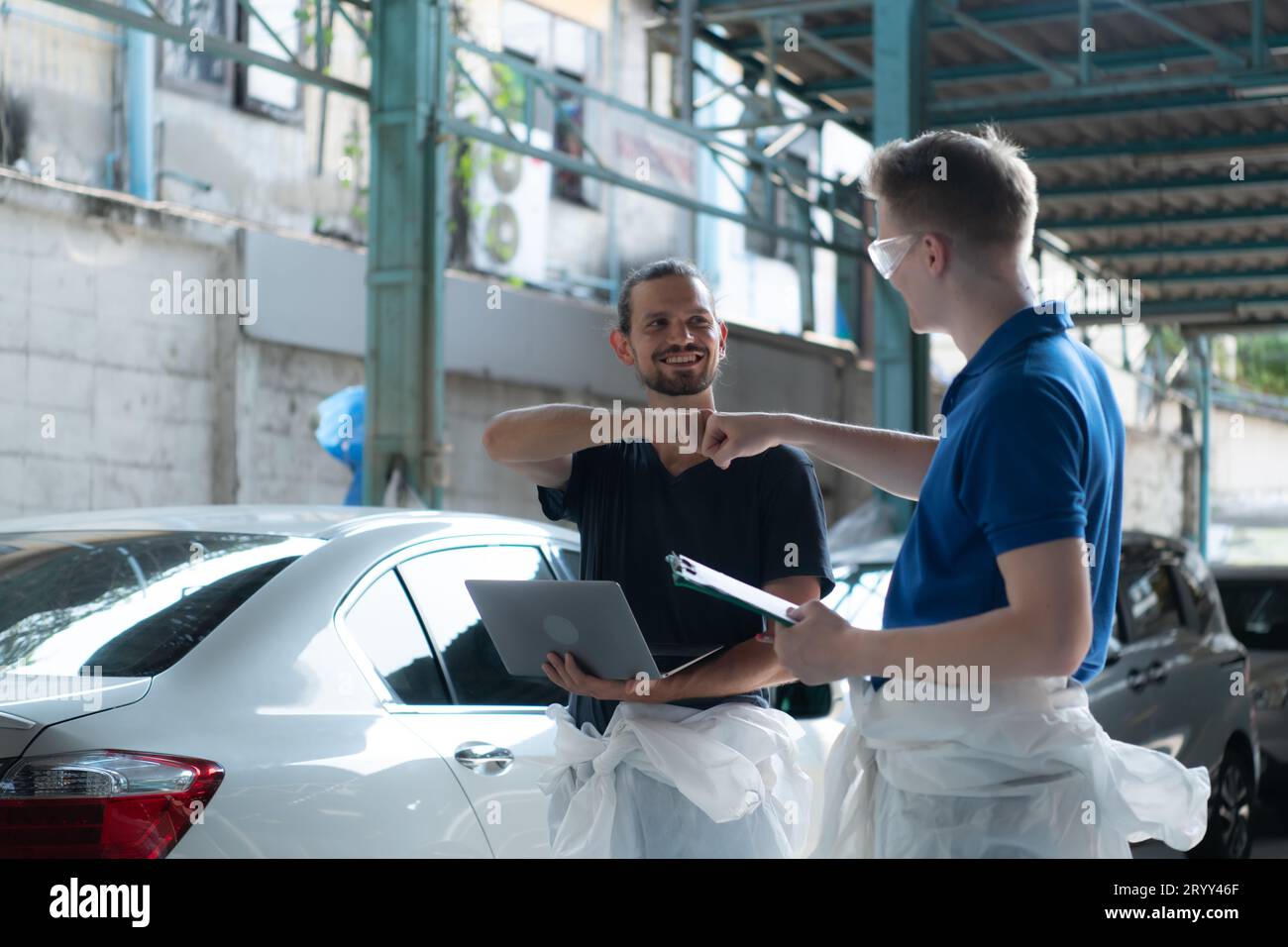 Both of technician inspects the condition of the car that has been polished and coated with glass. Stock Photo