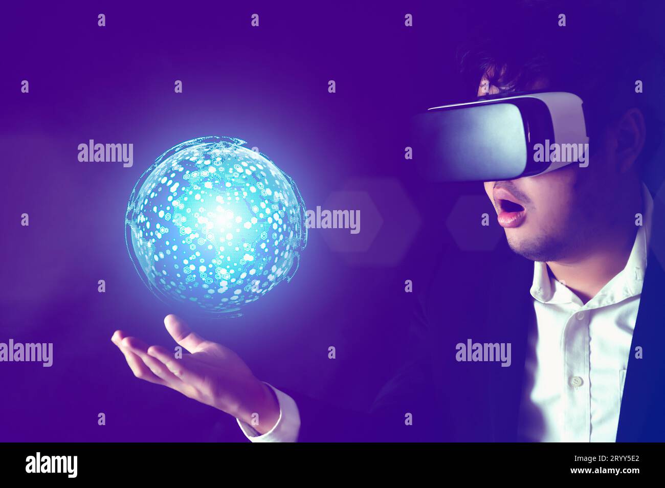 Businessman wearing Virtual reality headset with globe hologram on his hand. Business technology and Metaverse concept Stock Photo