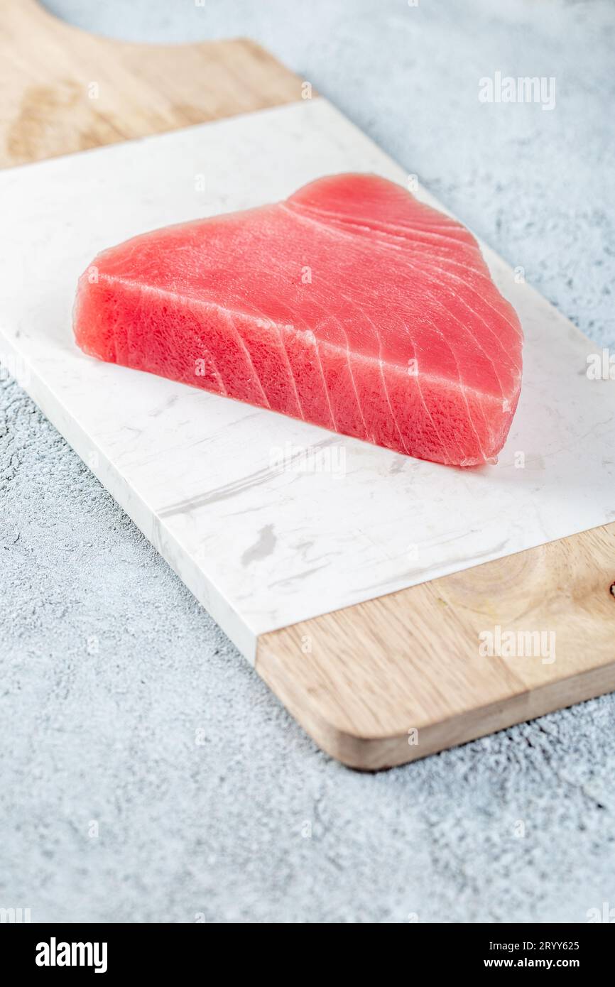 Raw tuna steak on white concrete background. Stock Photo