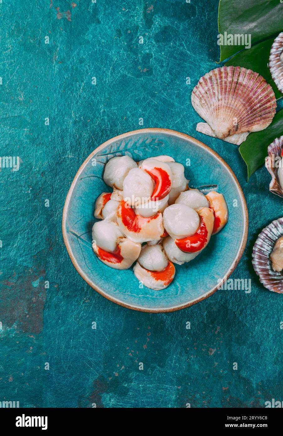 Raw fresh seafood shellfish scallops on blue background Stock Photo