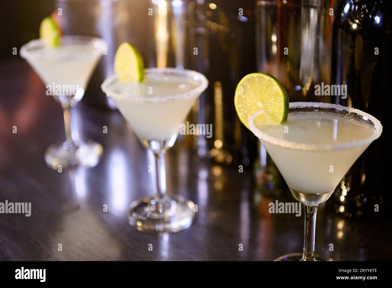 Closeup of lemonade drinks in martini glasses on bar in night club. Close up alcohol in pub restaurant. Food and beverage concep Stock Photo