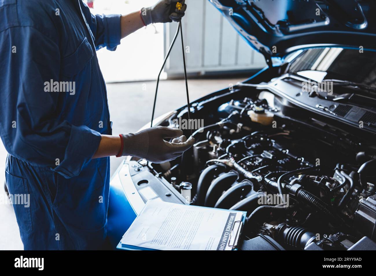 Car mechanic holding checking gear oil to maintenance vehicle by