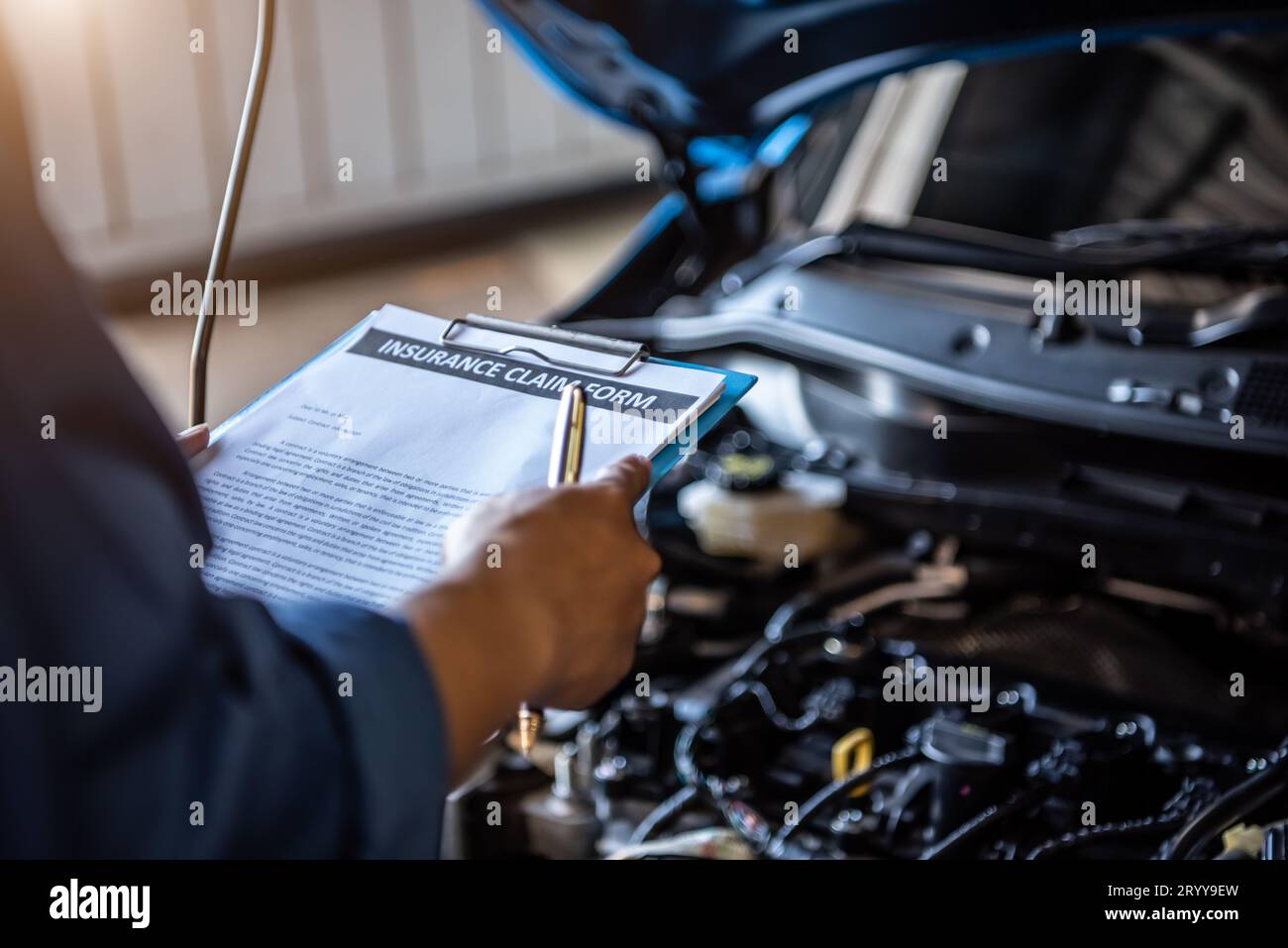 Car mechanic holding clipboard and checking to maintenance vehicle by customer insurance claim order in auto repair shop garage. Stock Photo