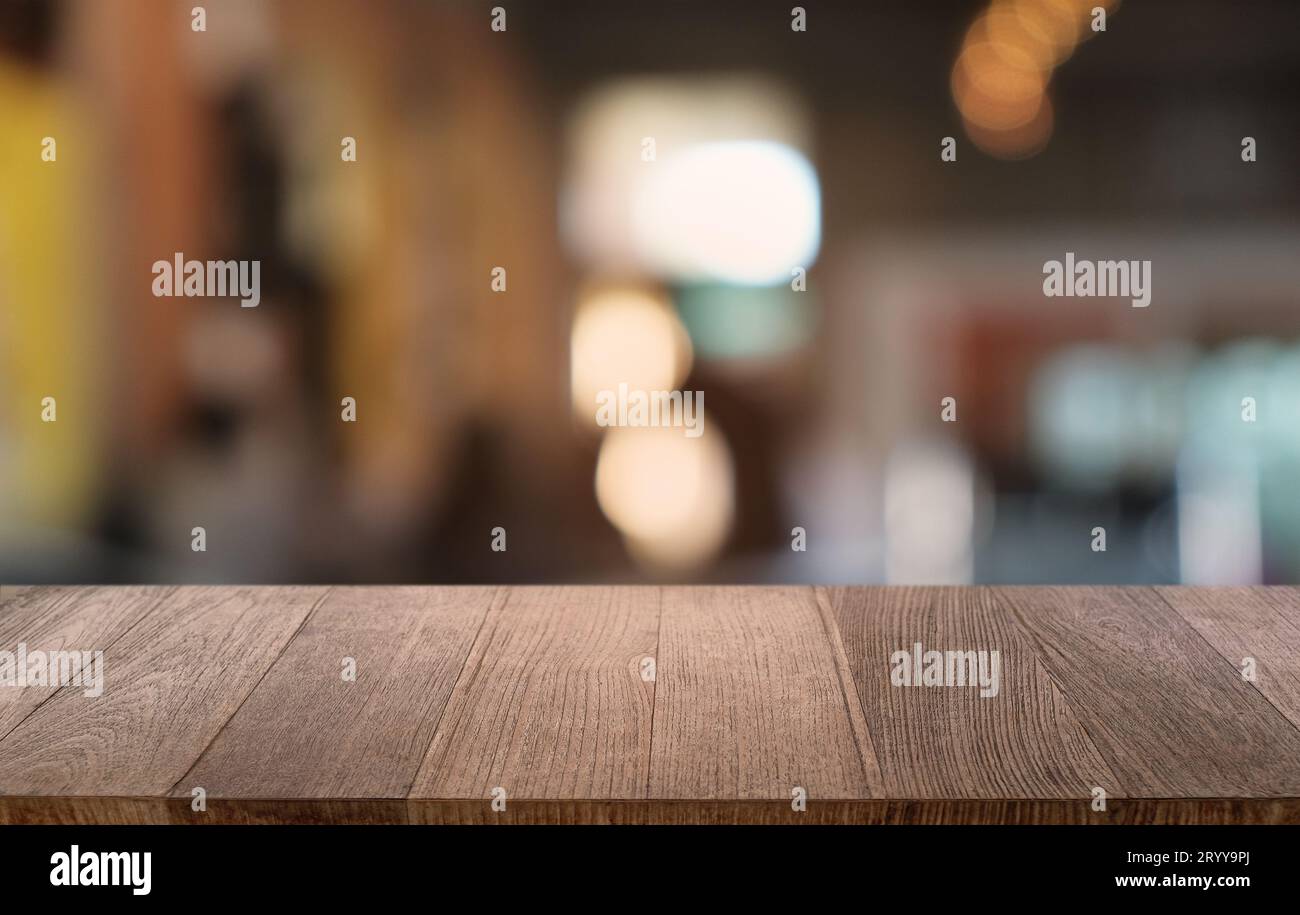 Empty dark wooden table in front of abstract blurred bokeh background of restaurant . can be used for display or montage your pr Stock Photo