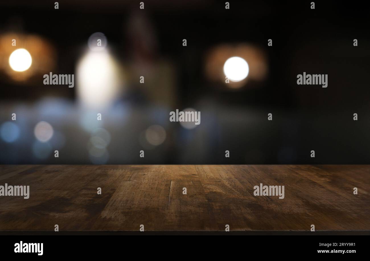 Empty dark wooden table in front of abstract blurred bokeh background of restaurant . can be used for display or montage your pr Stock Photo
