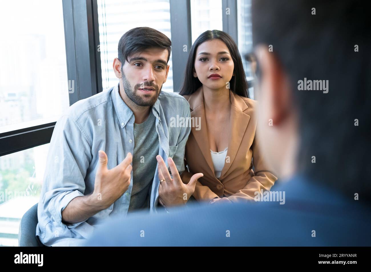 Psychotherapist inquiring about symptoms occurring within mind from patients with mental health problems in hospital. Group psyc Stock Photo