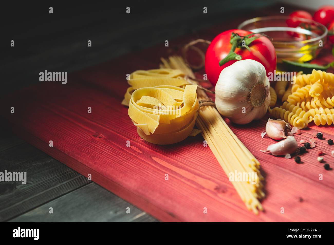 Tasty appetizing italian spaghetti pasta ingredients for kitchen cuisine with tomato, cheese parmesan, olive oil, fettuccine and Stock Photo