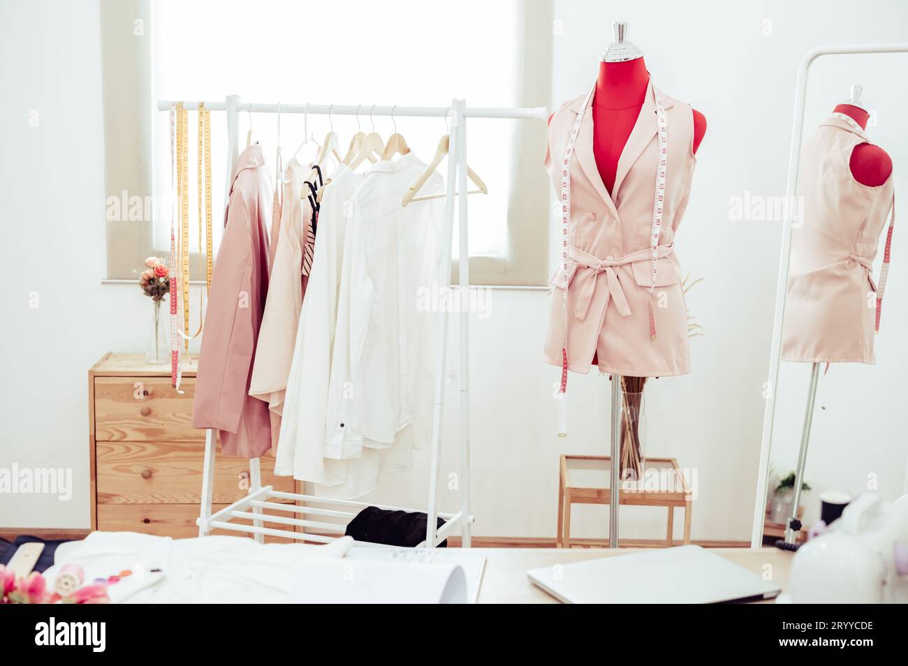 Fashion designer showroom studio workshop background with new collection of pink pastel female clothing design. Tailor and sewin Stock Photo