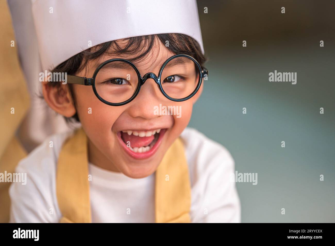 Portrait cute little Asian happy boy interested in cooking with mother funny in home kitchen. People lifestyles and Family. Home Stock Photo