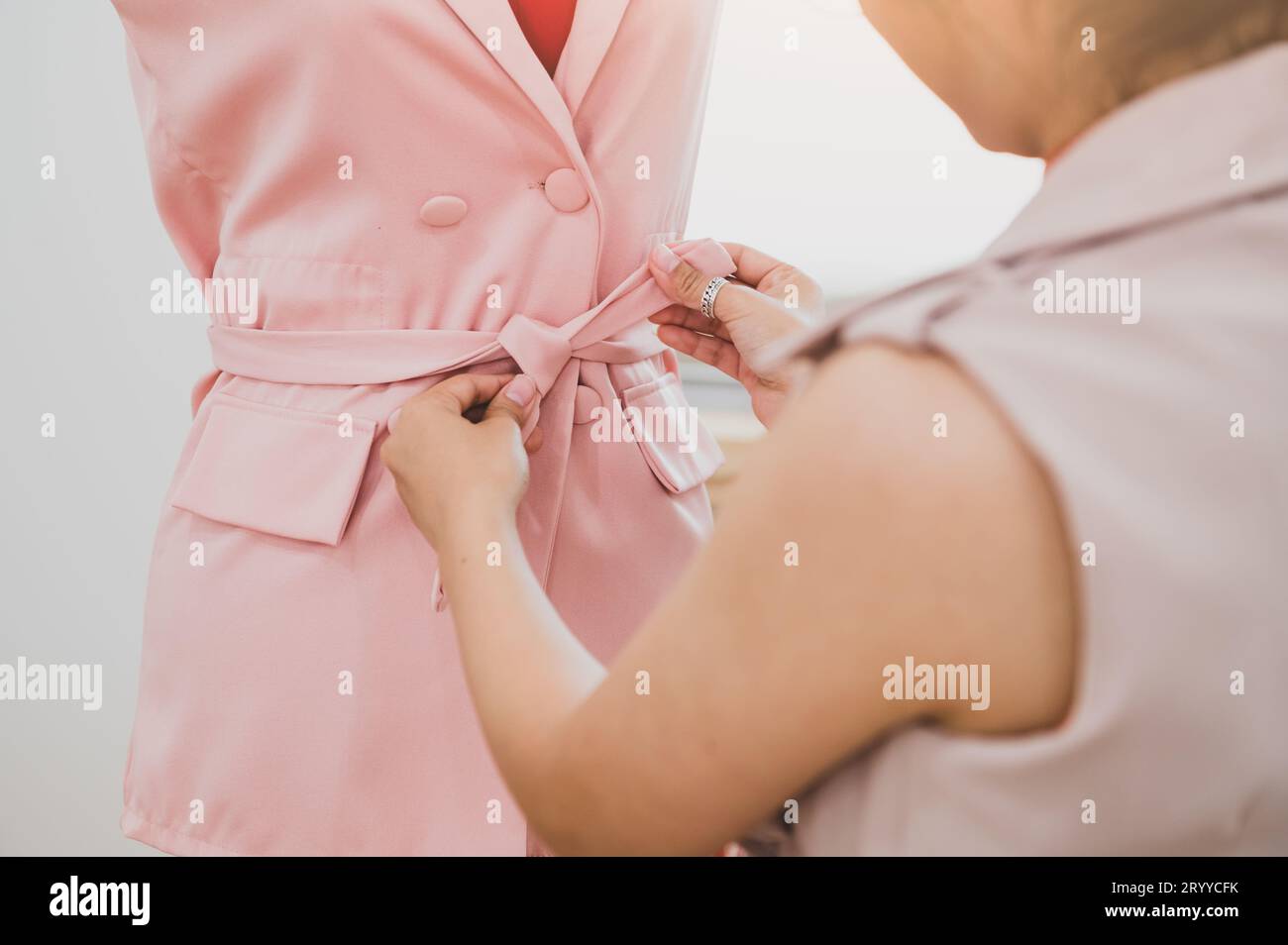 Asian female fashion designer girl making fit on the formal dress uniform clothes on mannequin model. Fashion designer stylish s Stock Photo