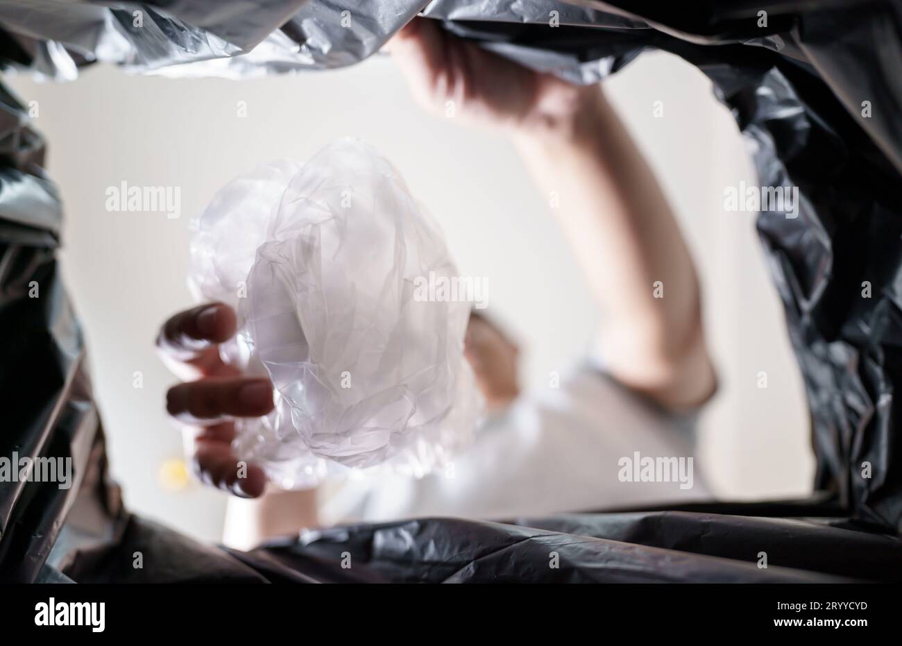 Image from inside yellow recycling bag of man throwing empty plastic bottle in recycling bin Home recycle eco green zero concept Stock Photo