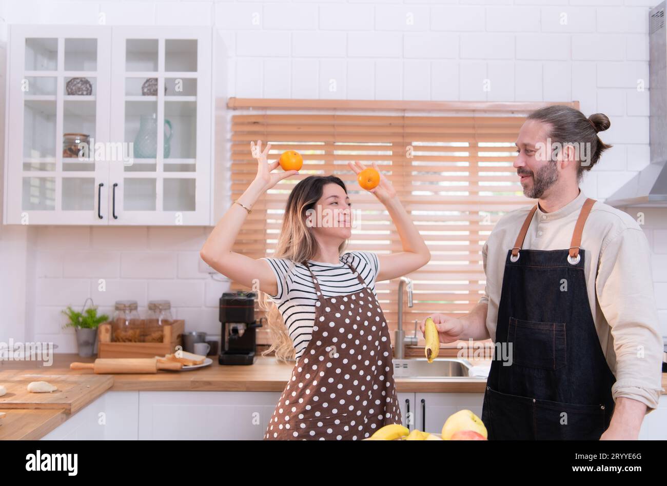 Father and mother in the house's kitchen have a good time making dinner ...