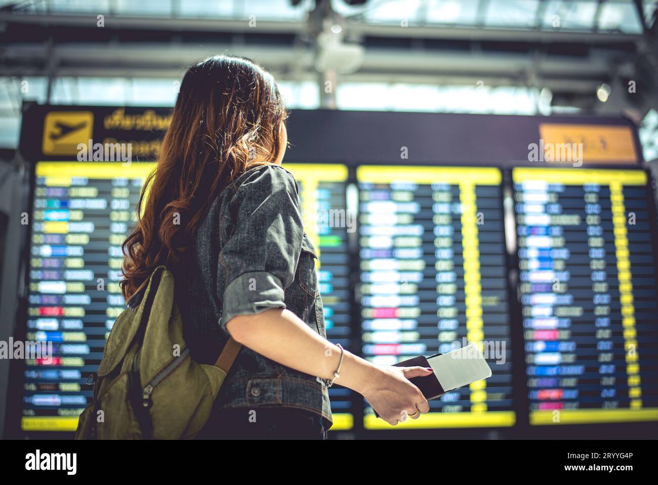 Beauty female tourist looking at flight schedules for checking take off time. People and lifestyles concept. Travel and Happy li Stock Photo