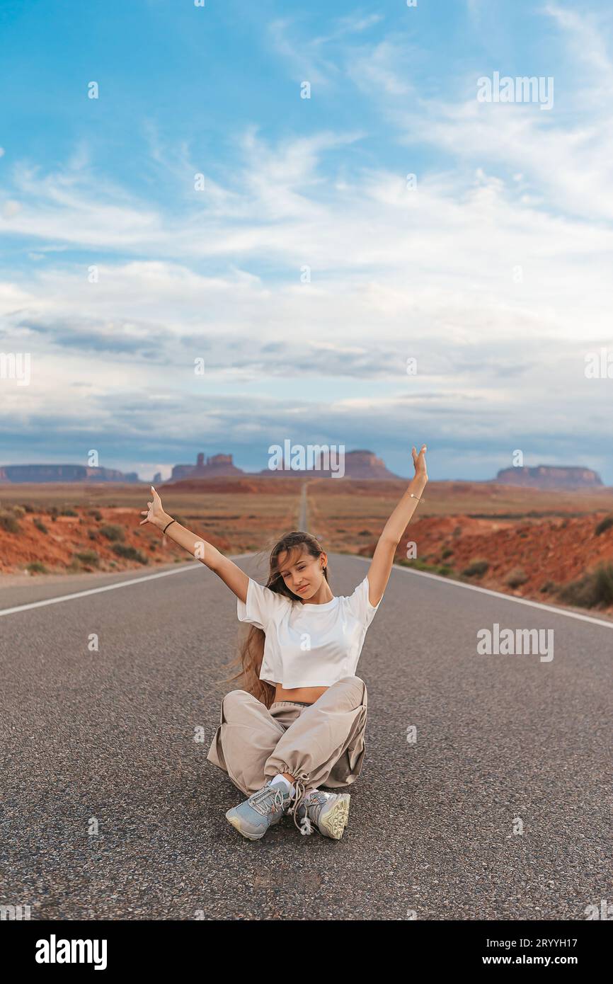 Scenic highway in Monument Valley Tribal Park in Utah. Happy girl on famous road in Monument Valley in Utah. Stock Photo