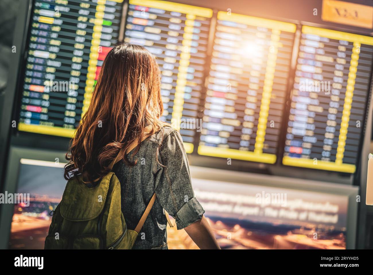 Beauty female tourist looking at flight schedules for checking take off time. People and lifestyles concept. Travel and Happy li Stock Photo