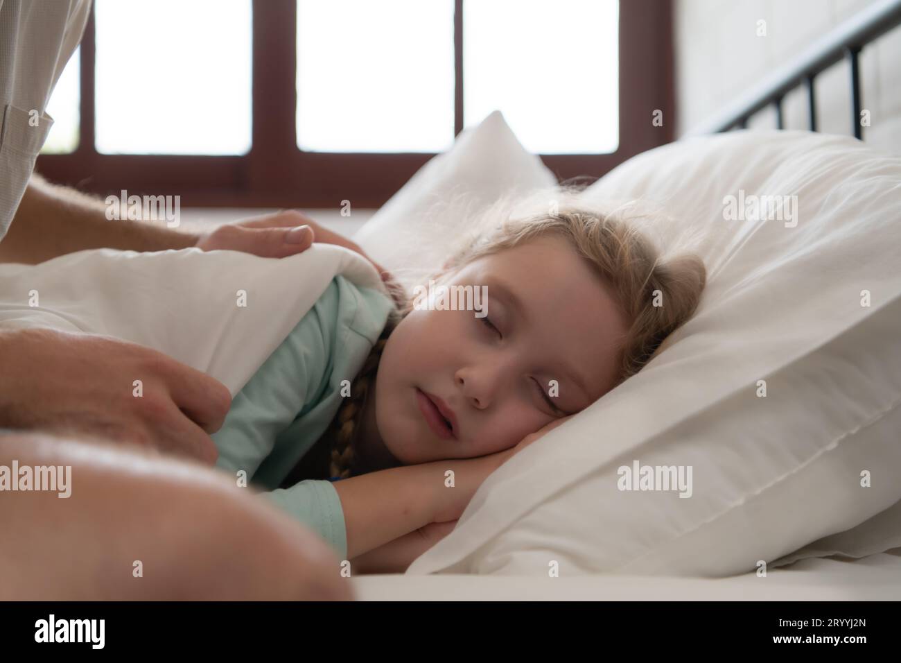 A father enjoys talking with his daughter in his bedroom. before saying goodbye and sending her daughter to bed Stock Photo