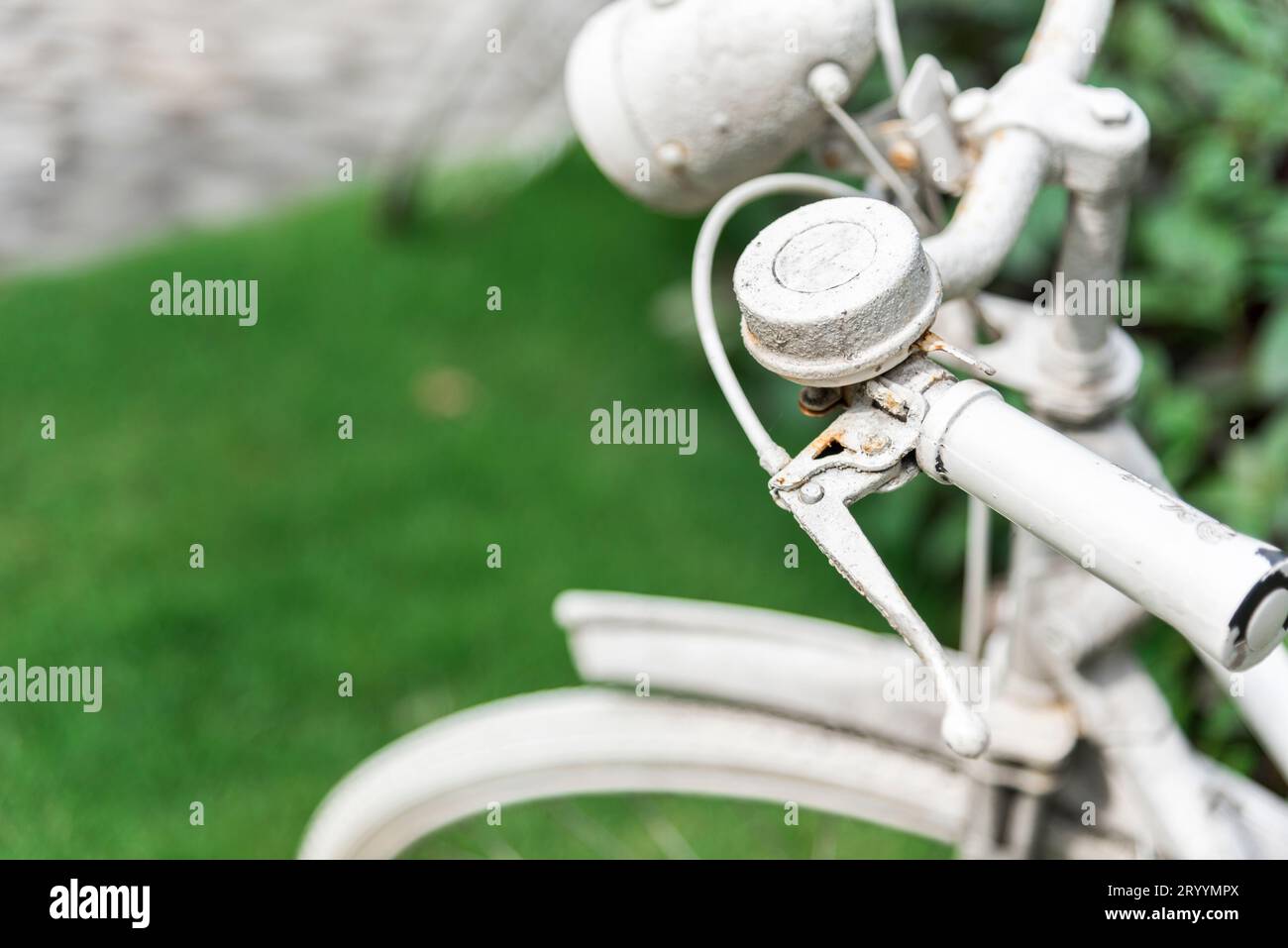 White bicycle in garden background. Vintage and nature concept. Close up and bike handle Stock