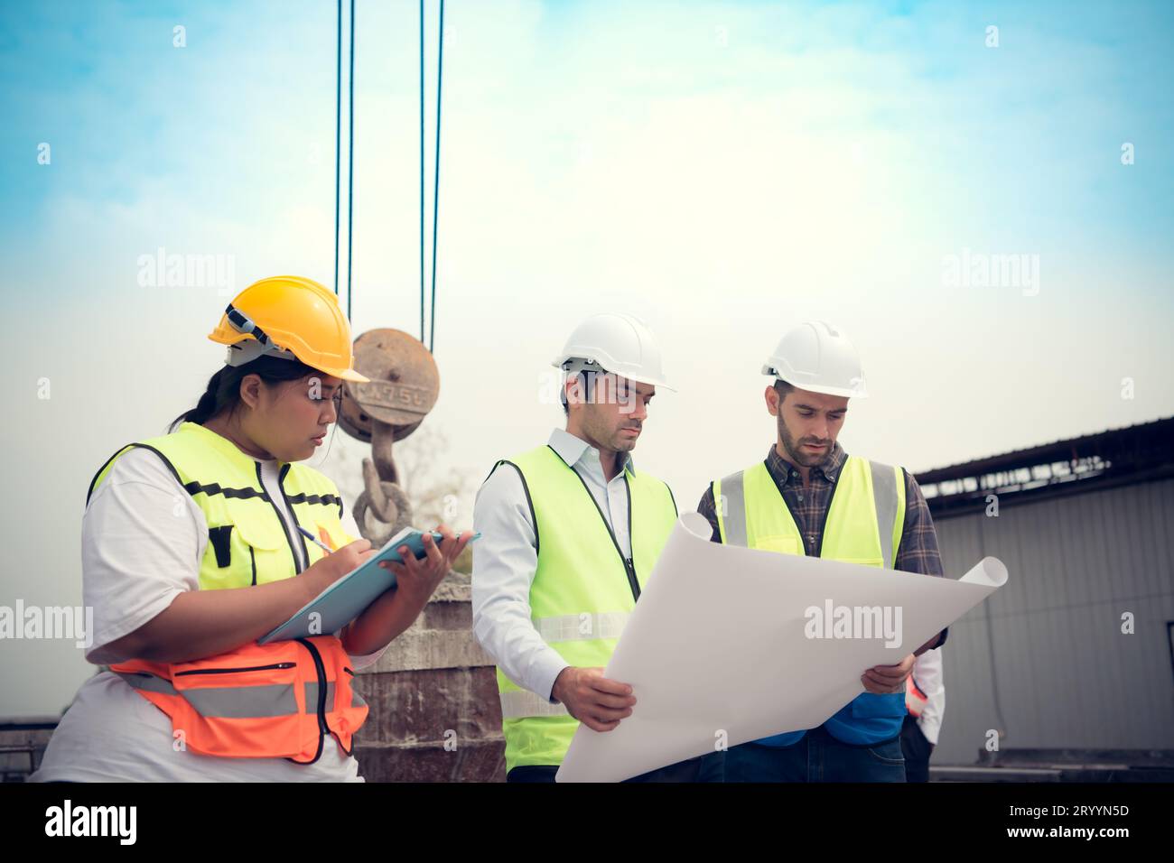 Group of architects, construction foremen, and construction engineers review the work and talk about how the project, in the con Stock Photo