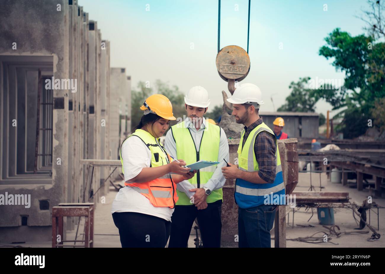 Group of architects, construction foremen, and construction engineers review the work and talk about how the project, in the con Stock Photo