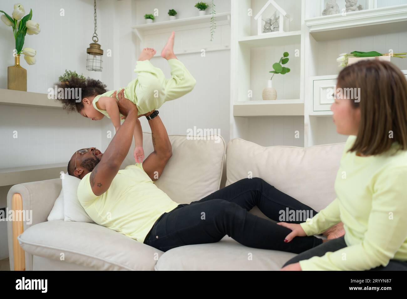 Parent having fun with his daughter by throwing up and lifting her up
