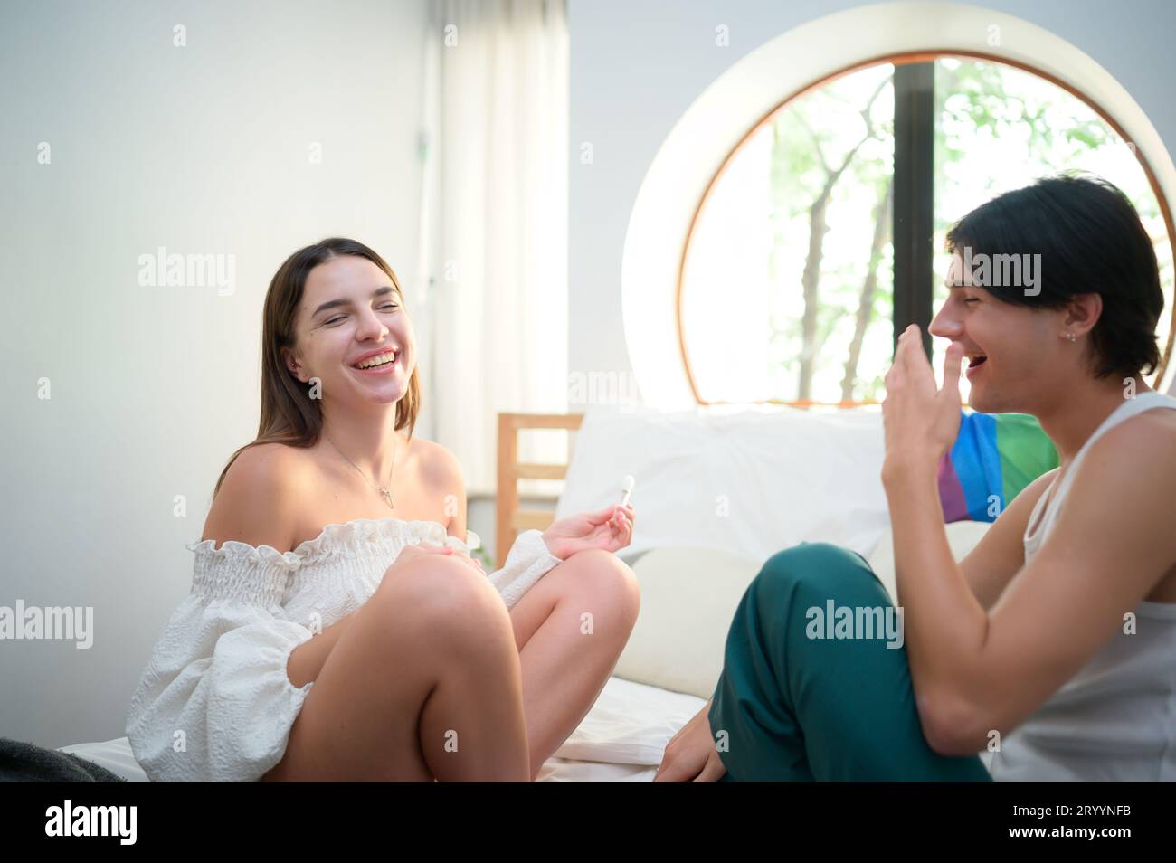 Friendship in about making up for differences. by a female friend putting lipstick on a gay friend Stock Photo