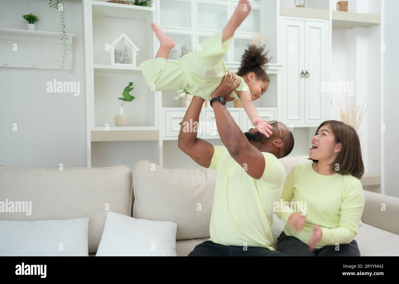 Parent having fun with his daughter by throwing up and lifting her up