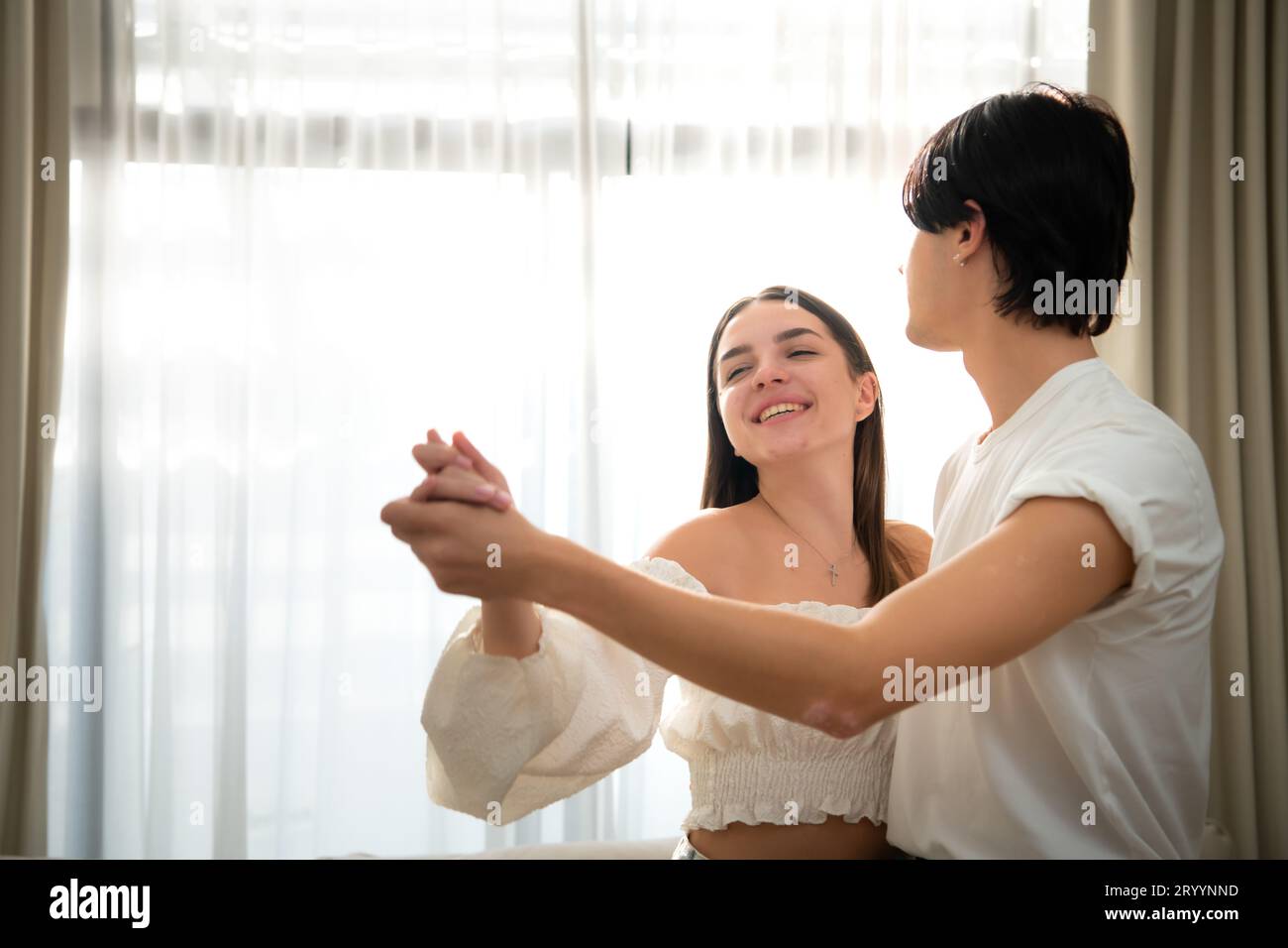 Young couple in the living room of the house in the morning, Dancing happily together Stock Photo
