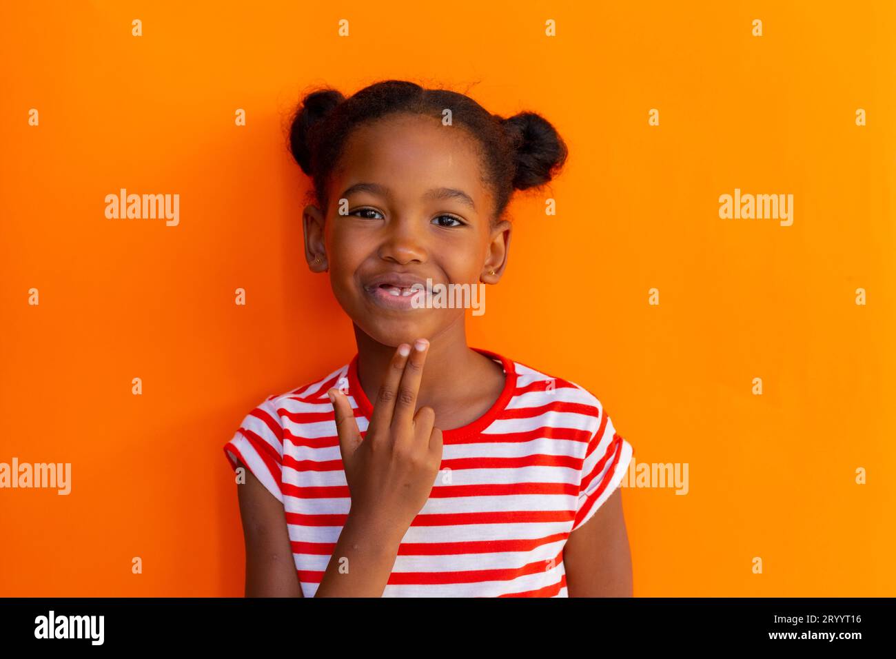 Happy african american schoolgirl going sign language with hand over orange background Stock Photo