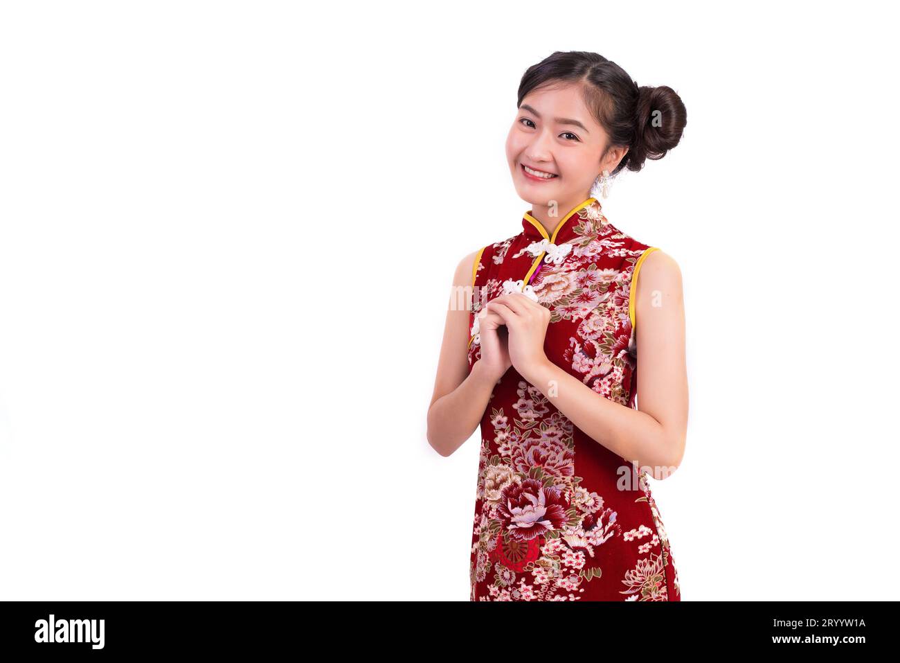 Young Asian beauty woman wearing cheongsam and blessing or greeting gesture in Chinese new year festival event on isolated white Stock Photo