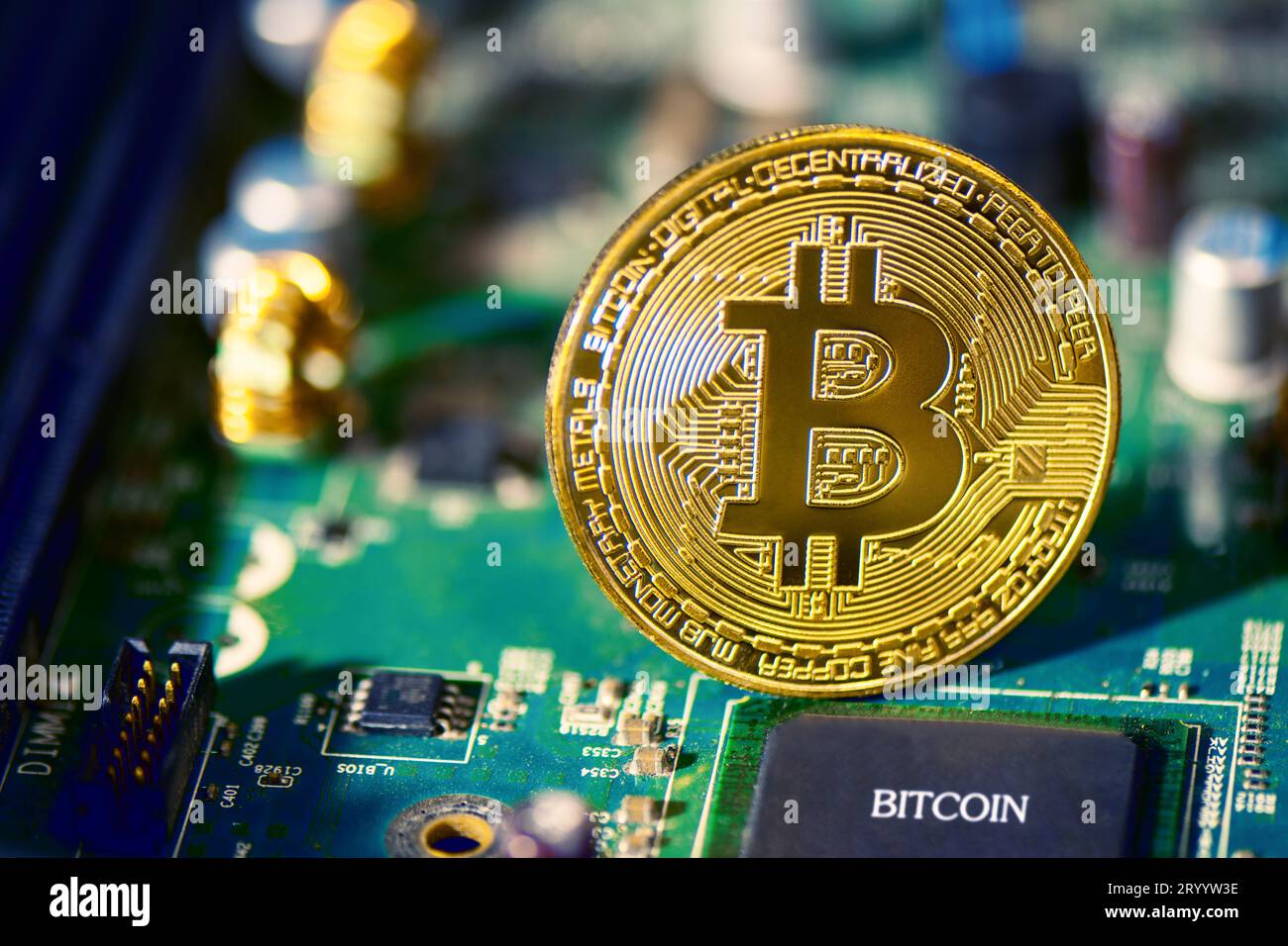 Bitcoin on electronic circuit board. Cryptography and Electronic money concept. Currency trading and Gold mining theme. Business Stock Photo
