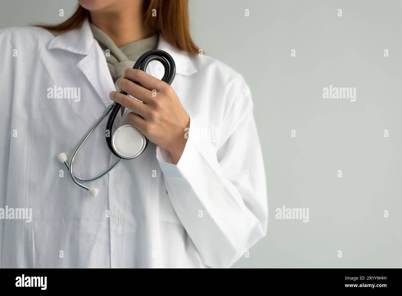 Female doctor is holding stethoscope and hear heart beat sound on white