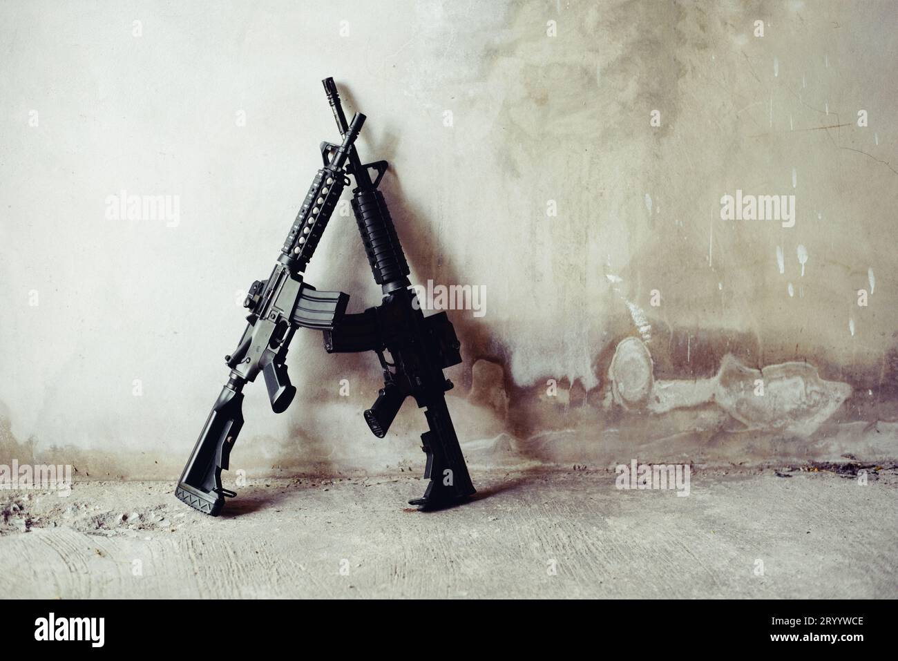 Rifle guns on grunge wall in abandoned house. Terrorist and Soldier concept. Robber and Police concept. War machine gun theme. Stock Photo