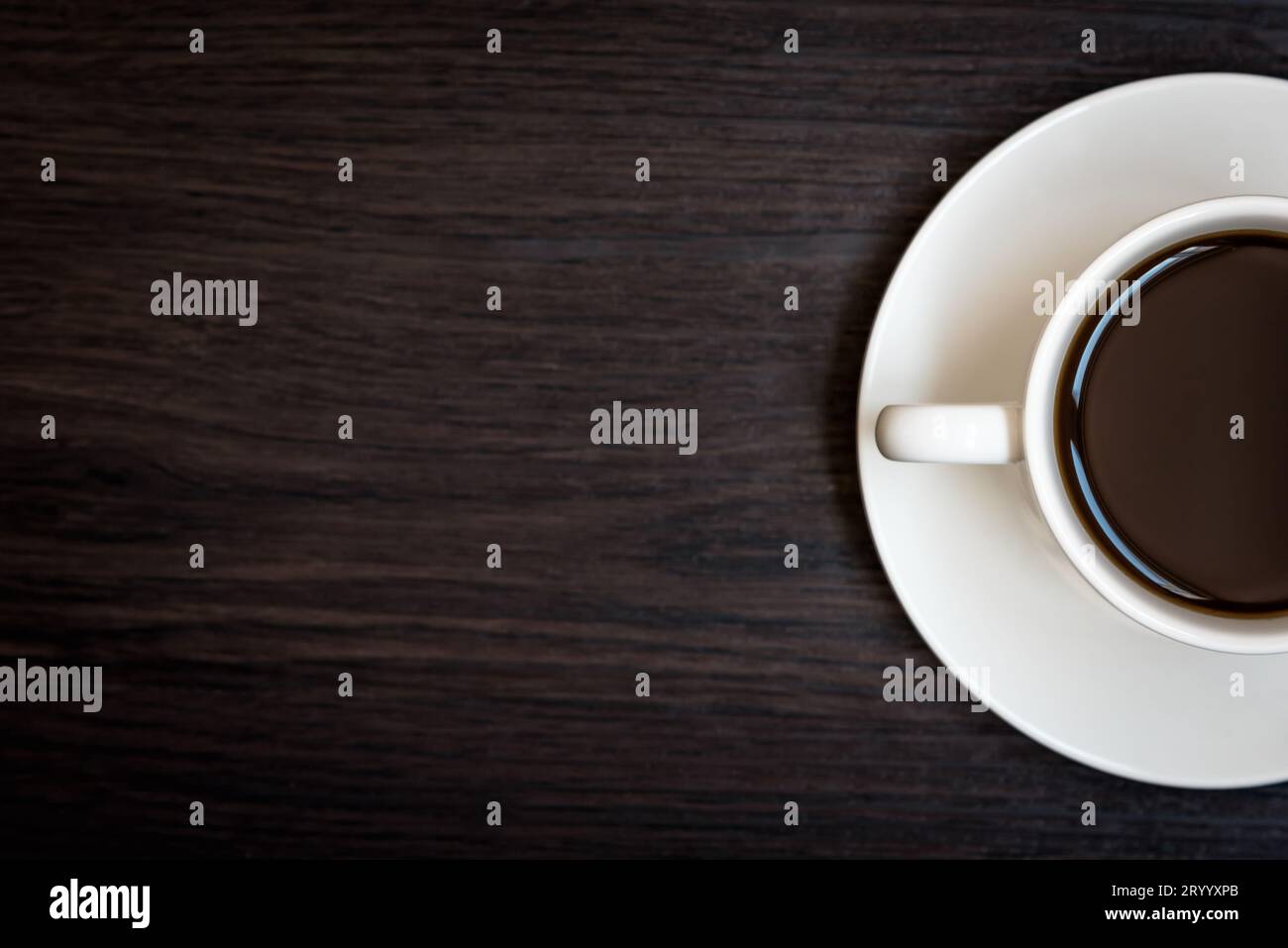 White coffee cup on wood table background with copy space, Half cup with full of coffee, Dark tone still life and vignette, Top Stock Photo