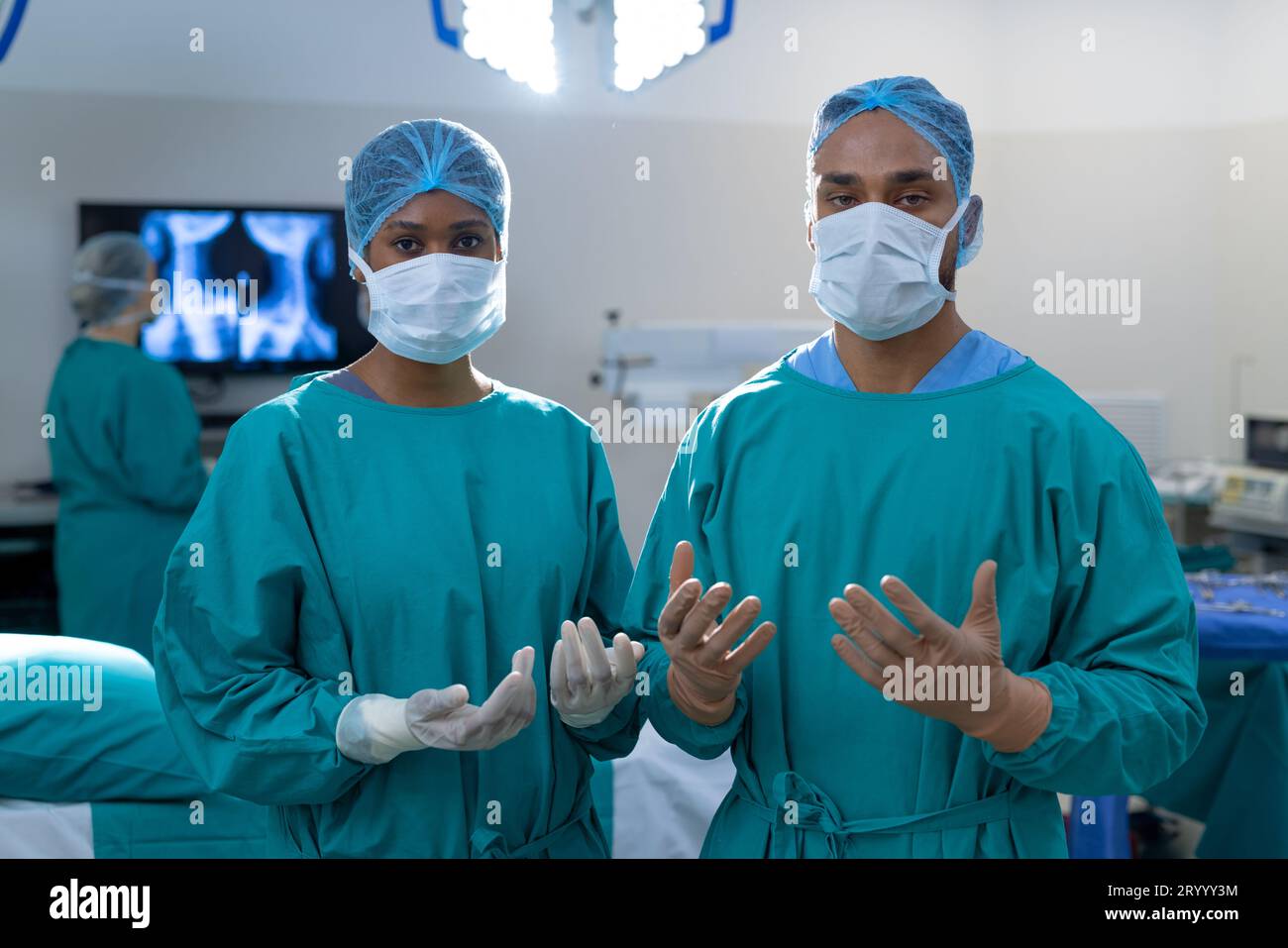 Portrait of diverse surgeons wearing surgical gowns in operating