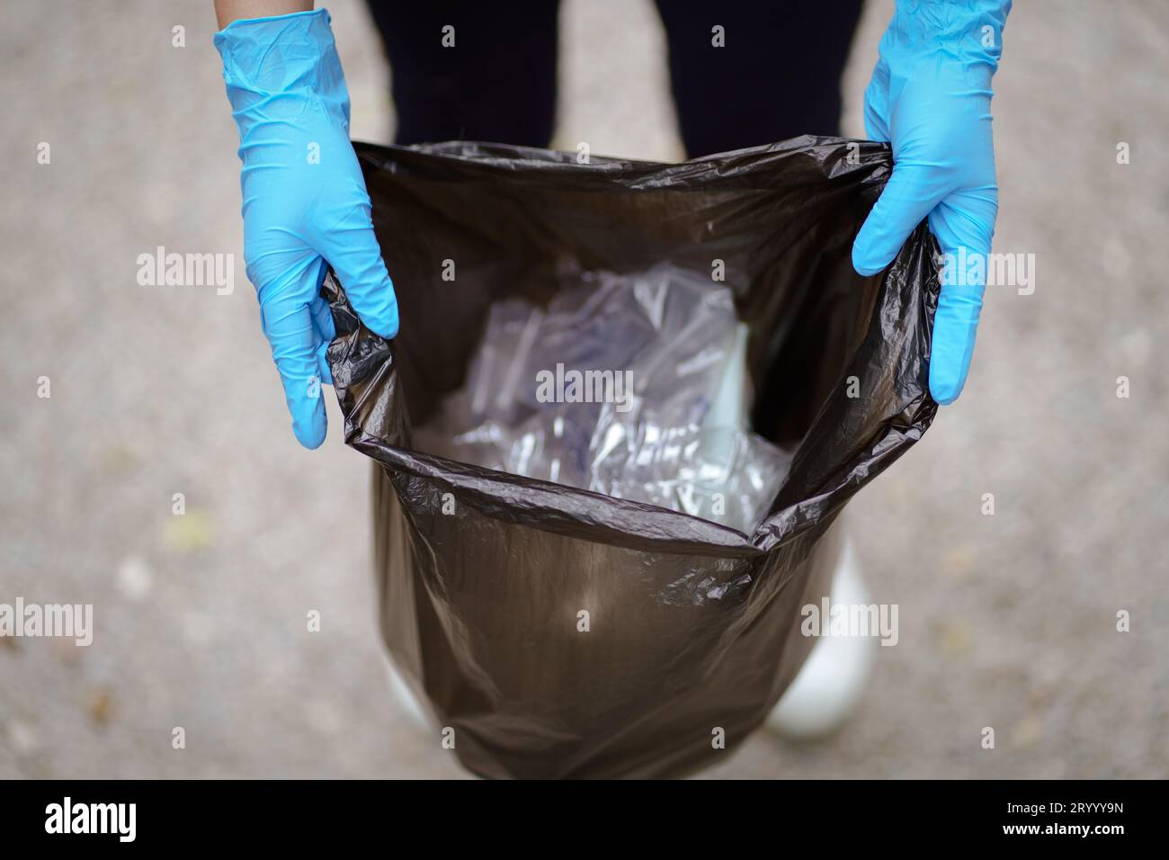 Volunteer charity womanÂ hand holding garbage black bag and plastic