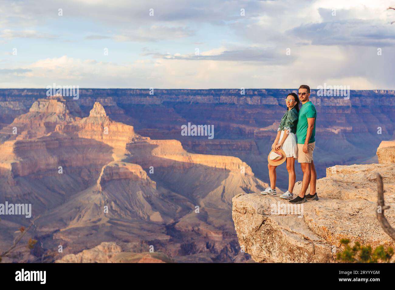 Happy couple on a steep cliff taking in the amazing view over famous ...