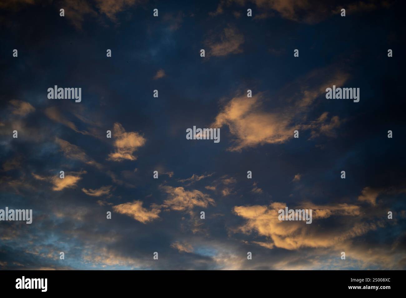 The setting sun illuminated the clouds. The light on the clouds. Stock Photo
