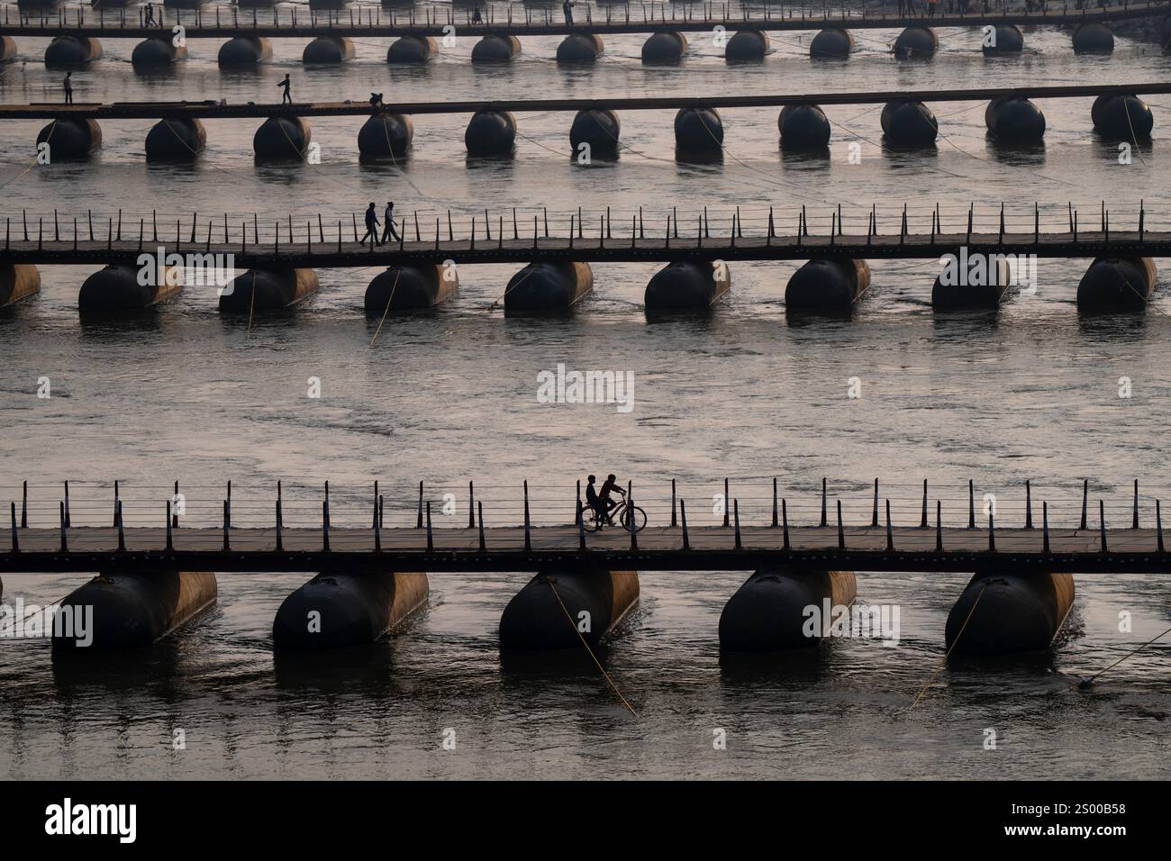 Prayagraj, India. 22nd Dec, 2024. General view of floating pontoon bridges on the banks of river Ganges, ahead of the Maha Kumbh Mela festival, at Sangam, the meeting point of the Ganges, Yamuna, and legendary Saraswati rivers in Prayagraj. A temporary city is being constructed around the sacred confluence of India's holiest rivers for the biggest assembly in world history. Credit: SOPA Images Limited/Alamy Live News Stock Photo