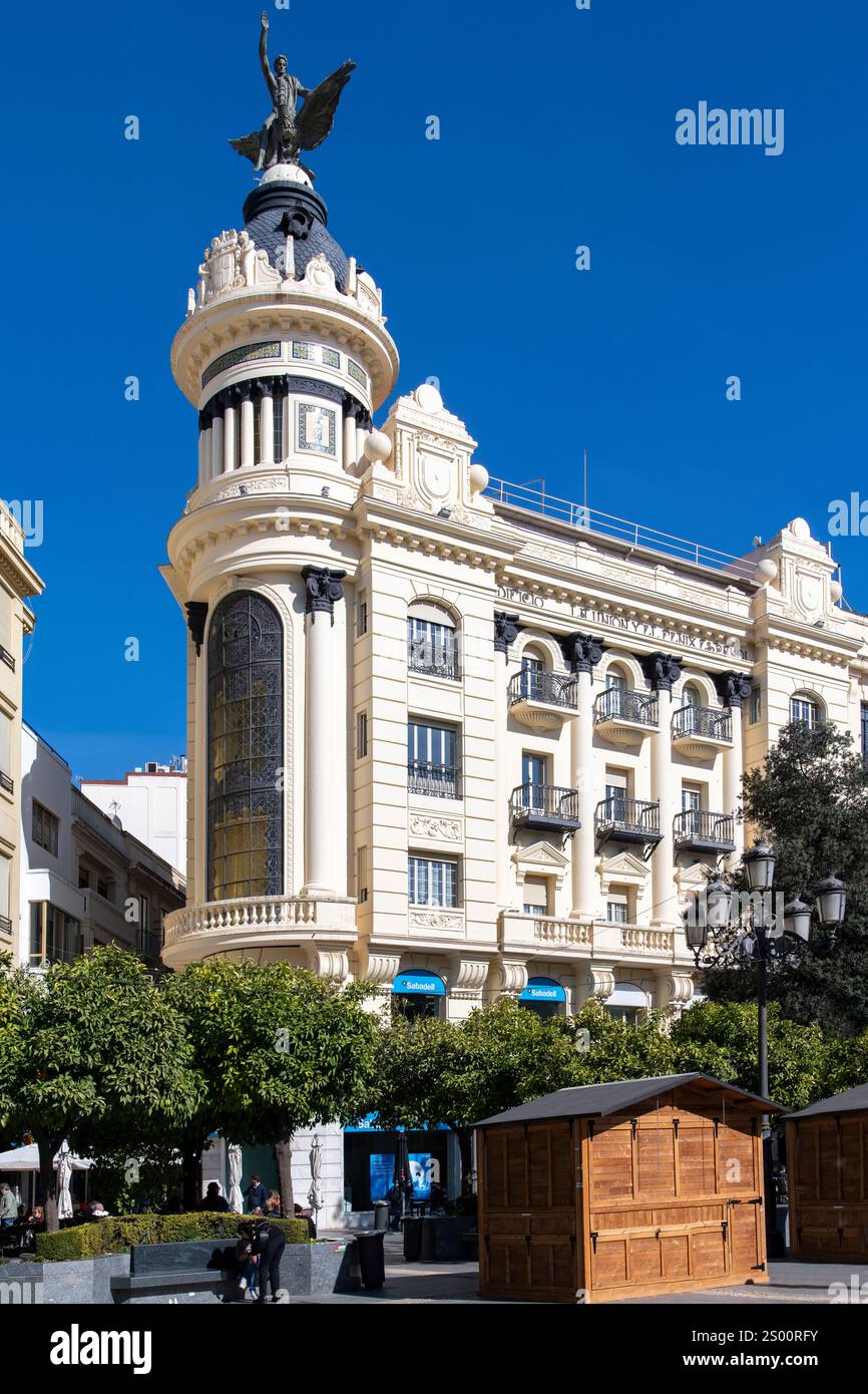 Cordoba, Andalusia, Spain-February 5, 2024; Low angle view of Union and Phoenix Building on Plaza de las Tendillas with Phoenix Bird and human figure Stock Photo
