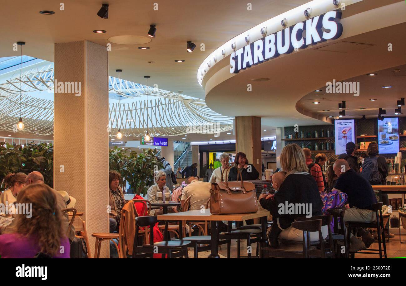 27 April 2024. Bristol Somerset England. Travellers take refreshments in the busy Starbucks Coffee Shop located in the Bristol Airport departures Stock Photo