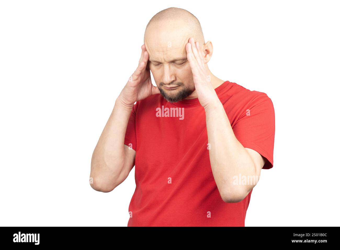 A man wearing a red T-shirt is holding his head with both hands, expressing pain, stress, or discomfort. Stock Photo