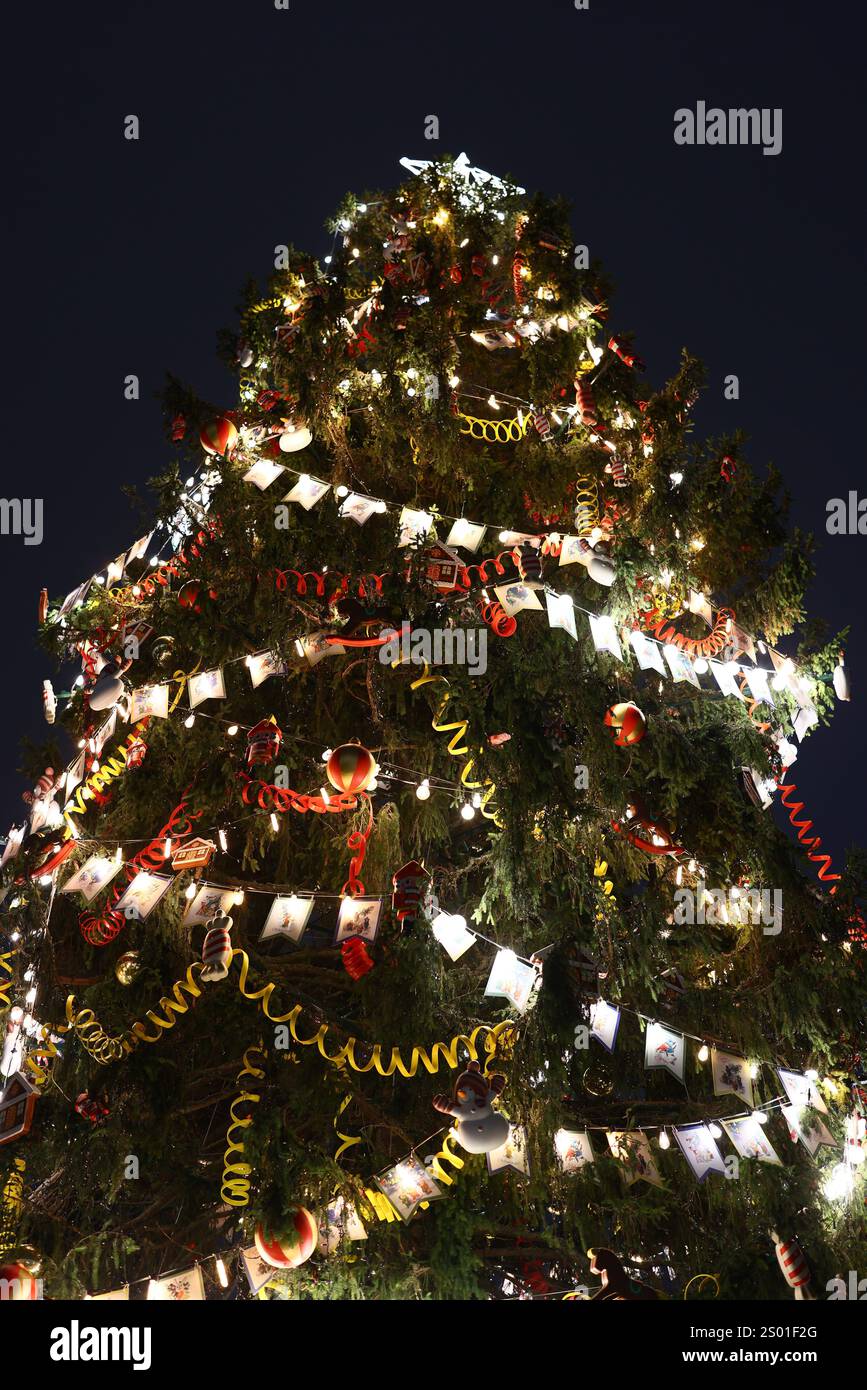 A beautifully illuminated Christmas tree that is adorned with an array ...