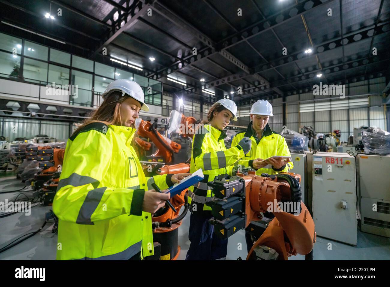 Engineering Safety Inventions Three engineers in safety gear examine plans and data while surrounded ...