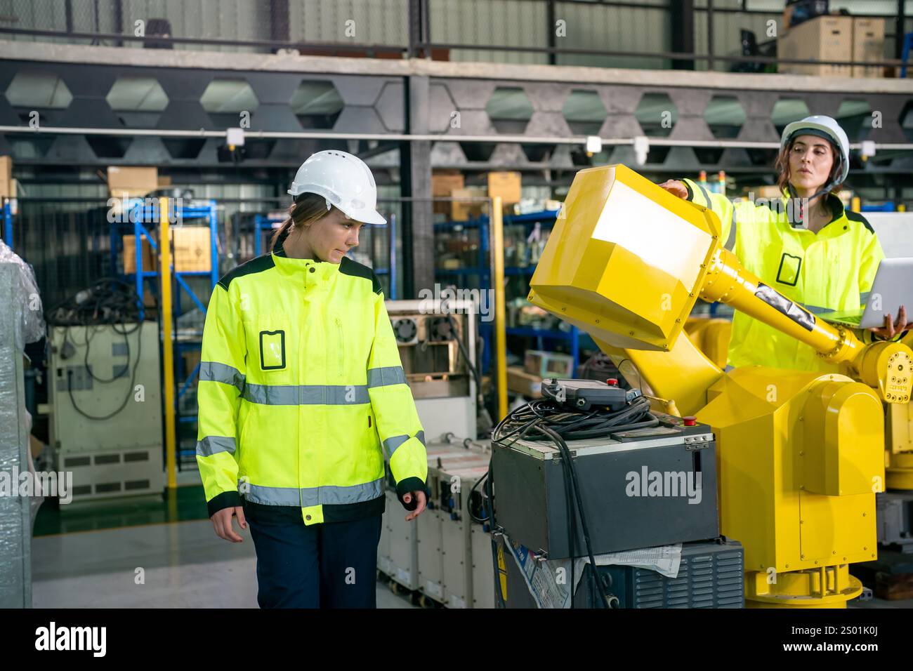 Two engineers wearing safety helmets and bright jackets are working ...