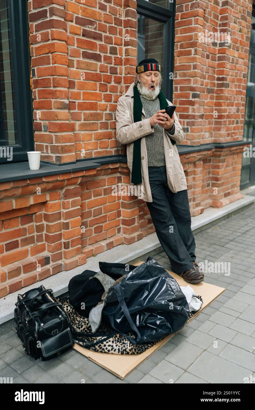 Full length vertical portrait of senior homeless man with white beard ...