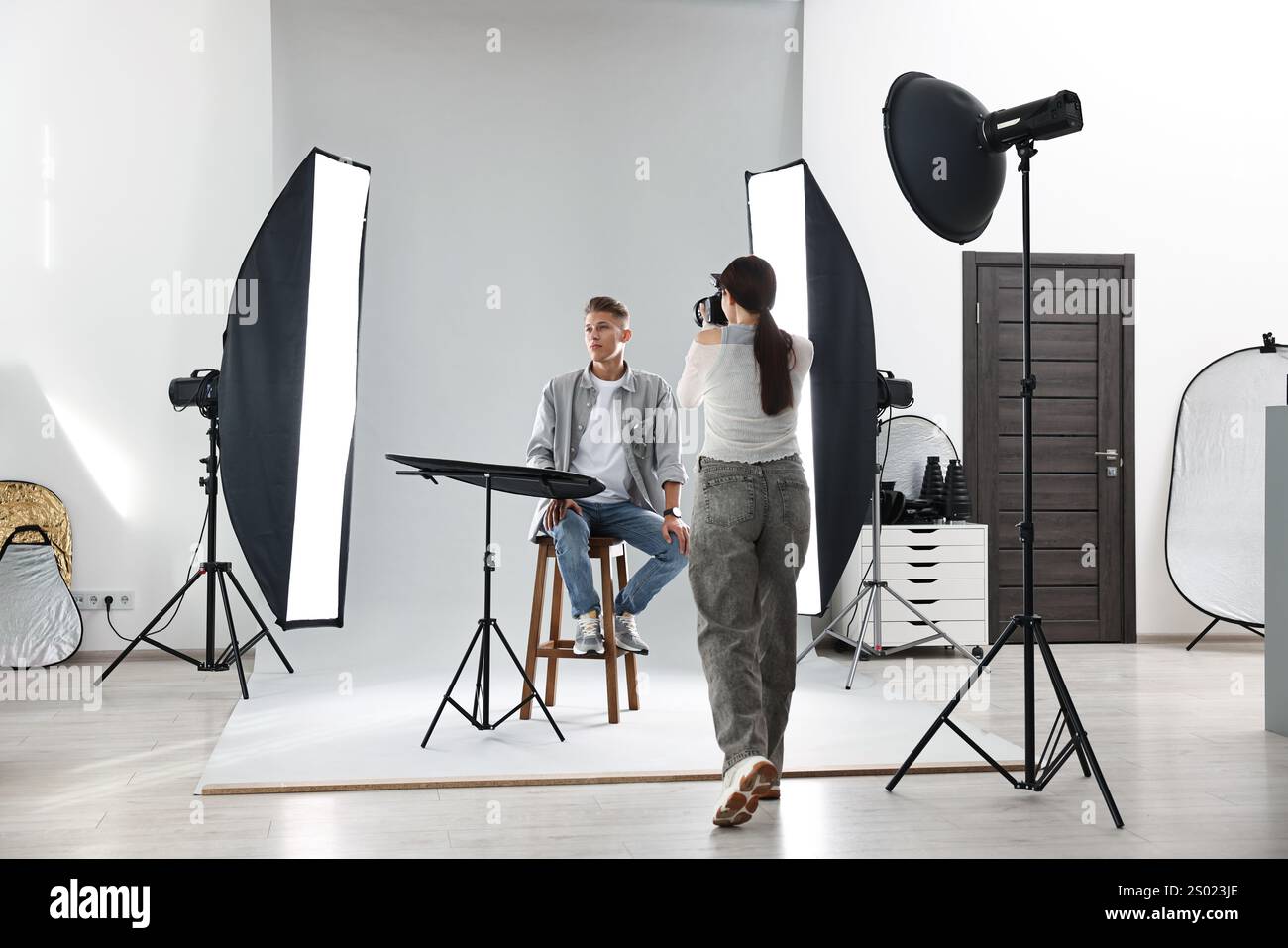 Photographer Using Model Photographer working with model in professional photo studio Stock ...