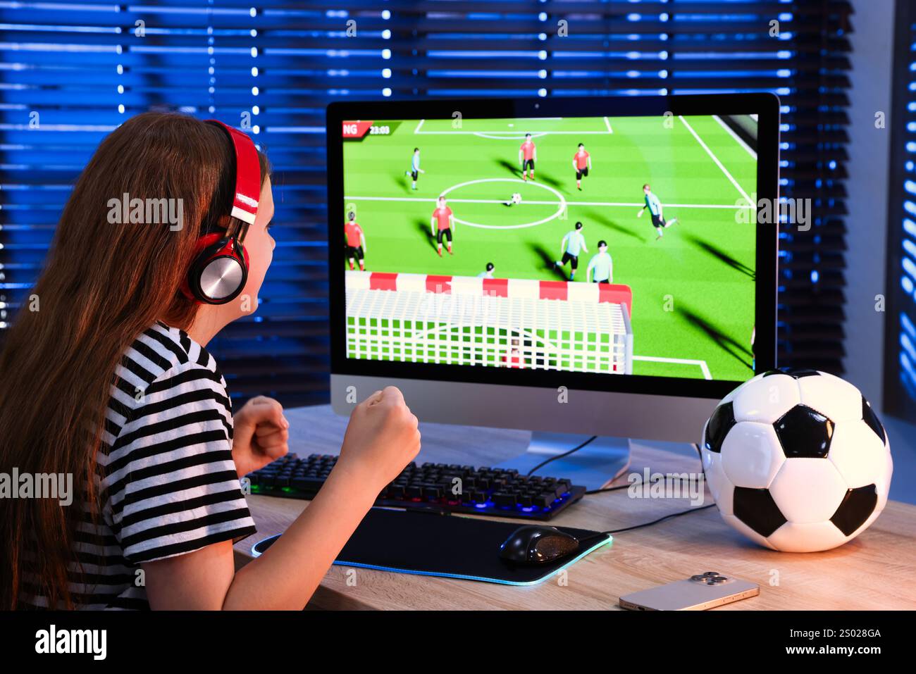 Football fan watching game live stream at table with computer keyboard ...