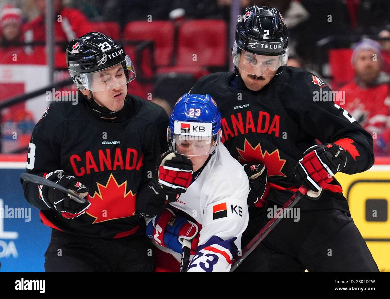 Canada's Tanner Howe (23) and teammate Andrew Gibson (2) give Czechia's