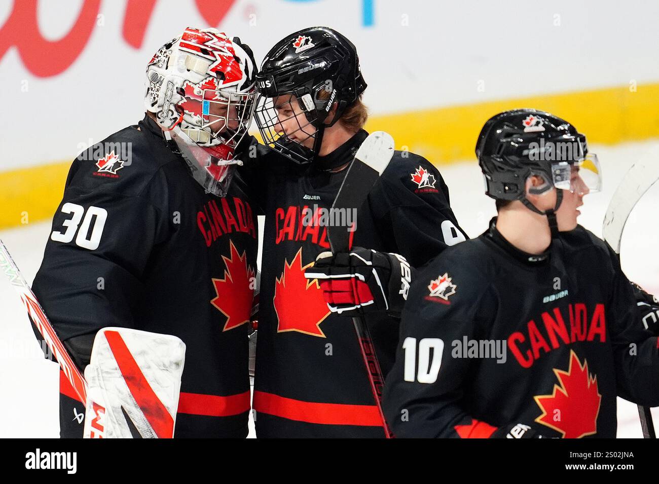 Canada's Gavin McKenna (9) and Canada's Carter (30) celebrate