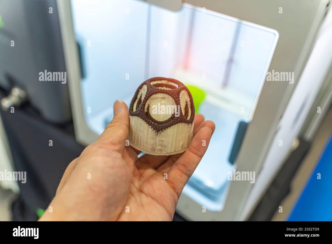 hand with hollow sphere object printed on 3d printer close-up Stock Photo